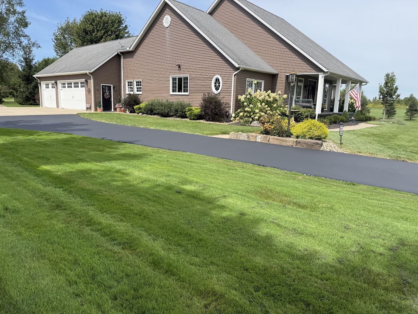 Paved asphalt driveway in front of a brick house